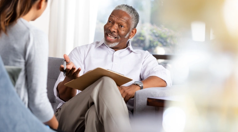 Elderly man talking with a young woman.