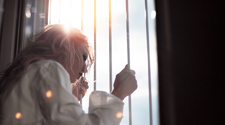 Pensive woman in sunlight indoors