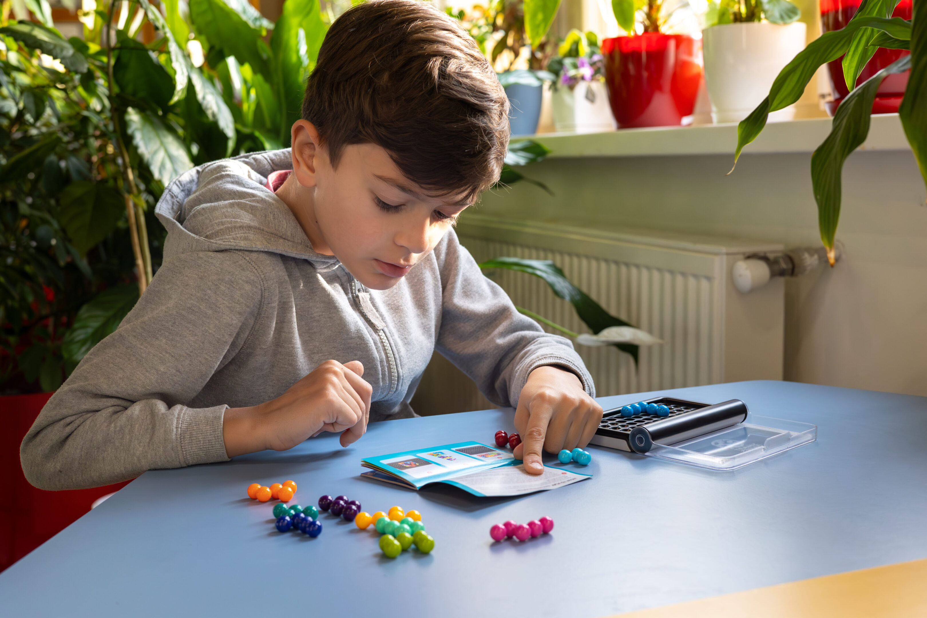 A young boy engaged in a logical board game, fostering child development, intellectual growth, and mental well-being in a supportive, inclusive environment. Focus on psychology, therapy