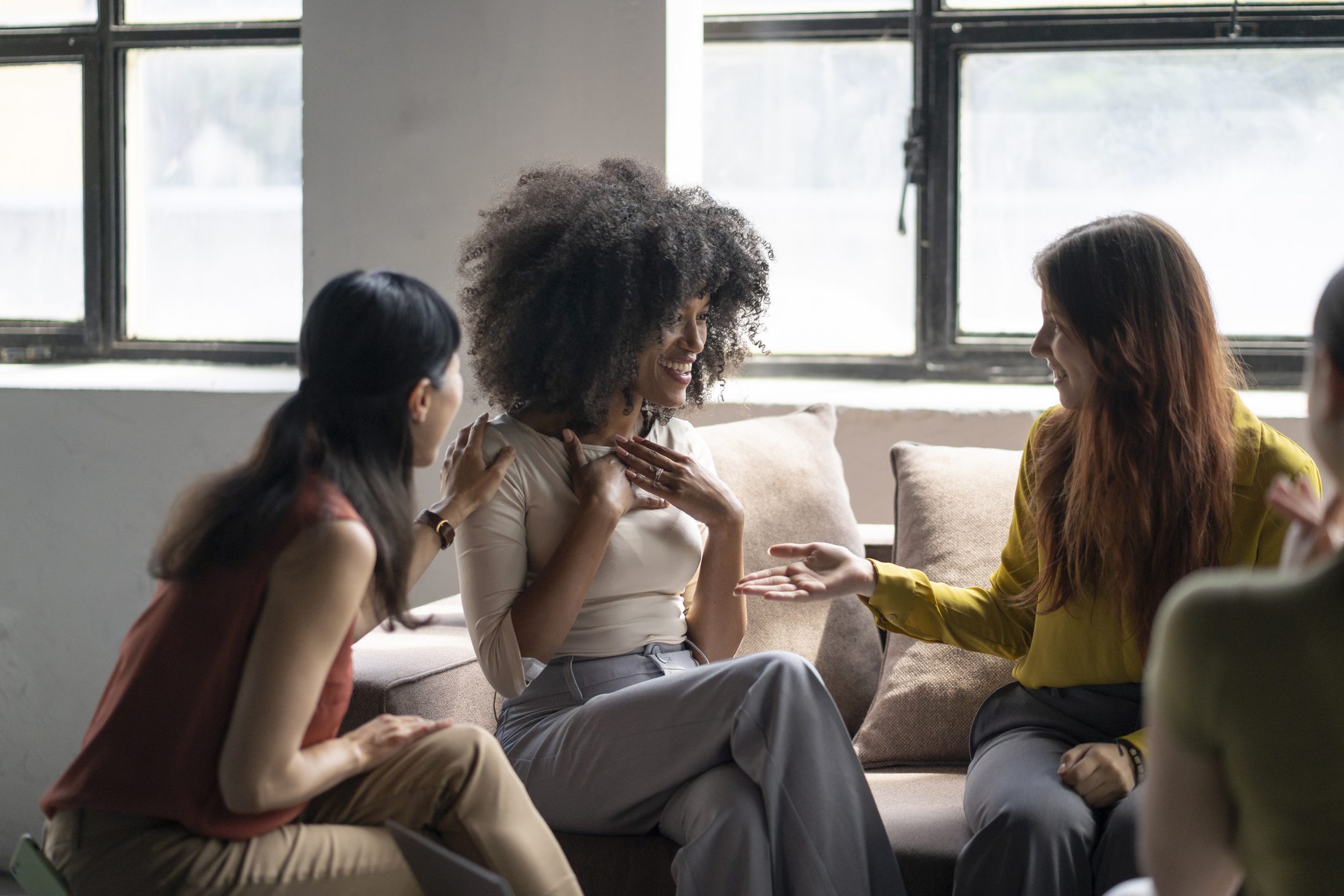 Diverse group of women comforting and supporting each other during a therapy session, showing empathy and understanding