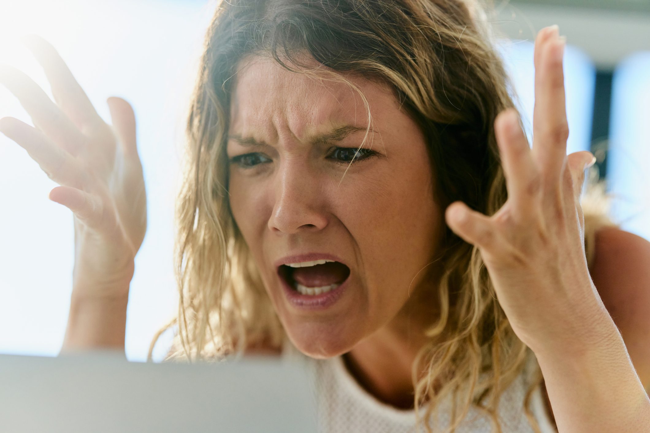 Displeased female entrepreneur arguing with someone during a conference call over a computer in the office.