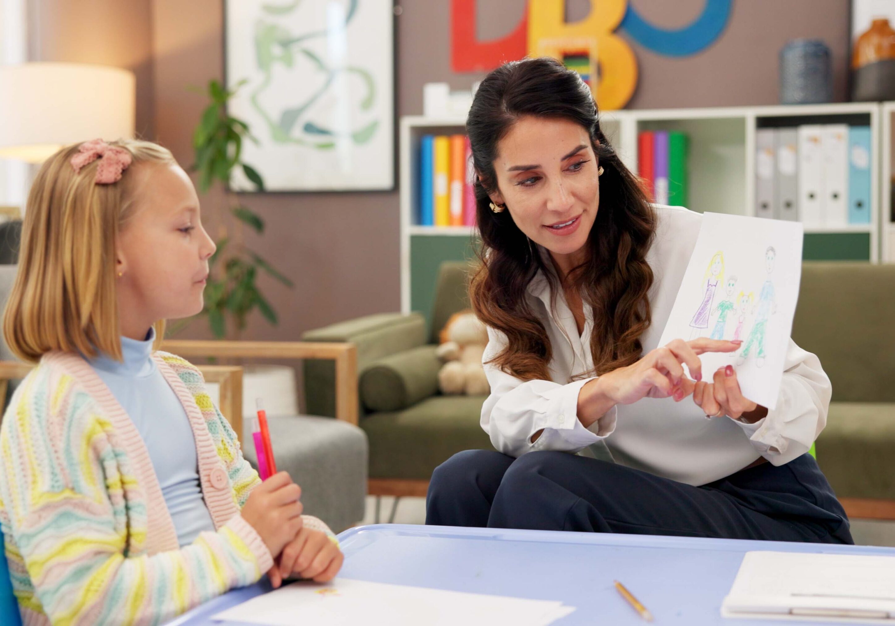 Counseling, kid and drawing with woman in psychology office for consulting, child development and art therapy. Education therapist, advice and mental health evaluation with person and girl in clinic